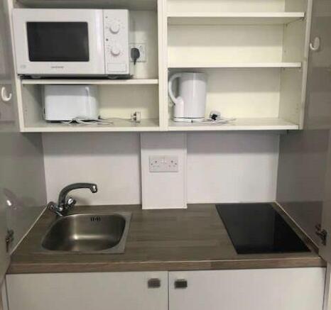 Compact and tidy kitchenette featuring essentia...