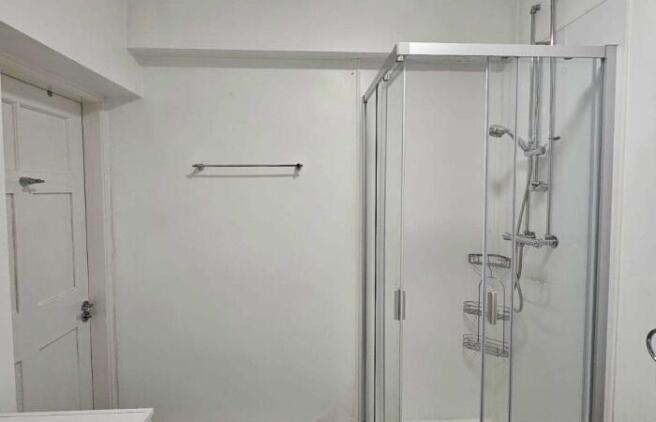 A clean and modern bathroom featuring a glass-e...
