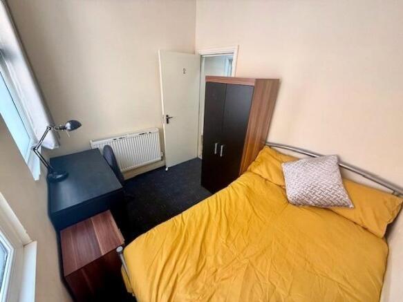 Bright double bedroom featuring a comfortable d...
