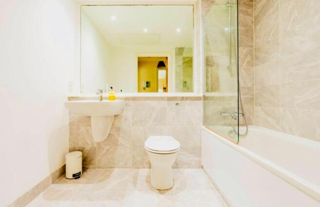 A modern bathroom suite featuring a clean white...