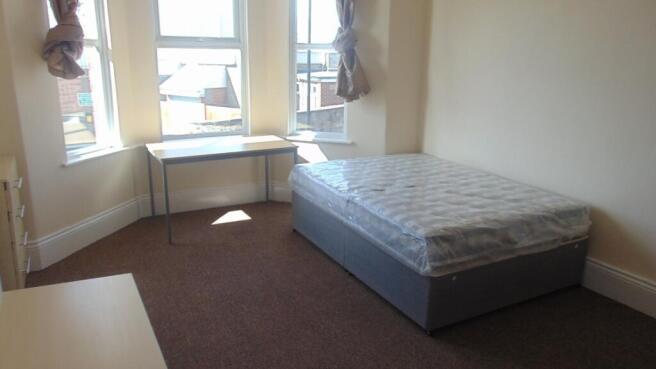 Bright single bedroom featuring a large bay win...