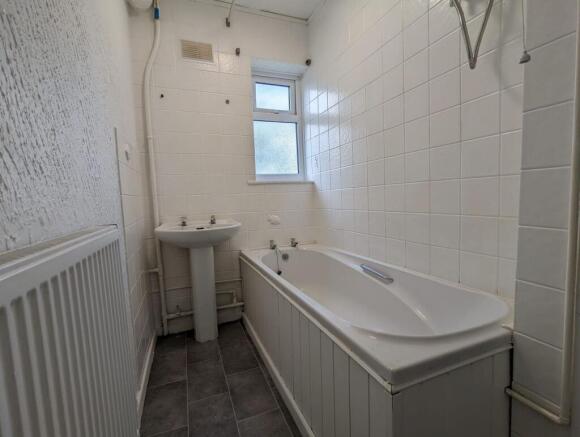 A bright bathroom suite featuring a white batht...
