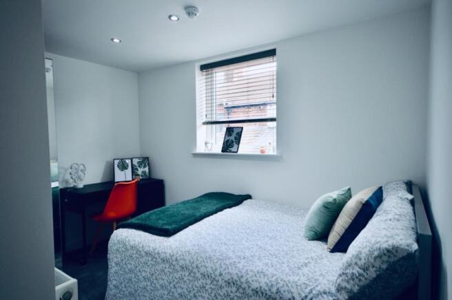 This inviting double bedroom boasts a cozy atmo...