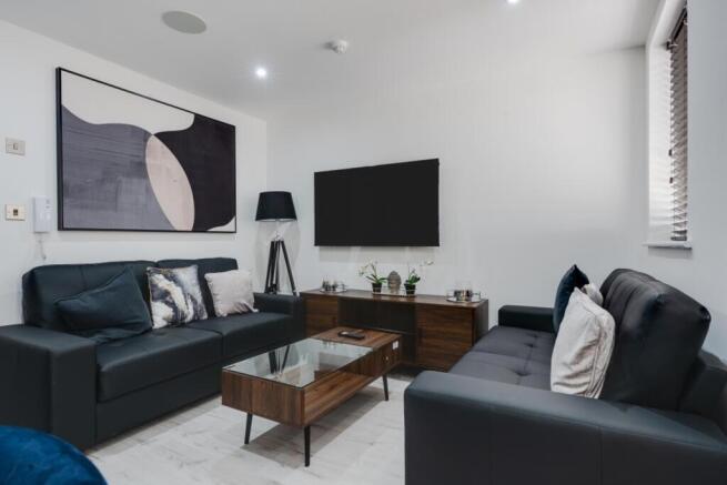 A stylish and contemporary living room featurin...
