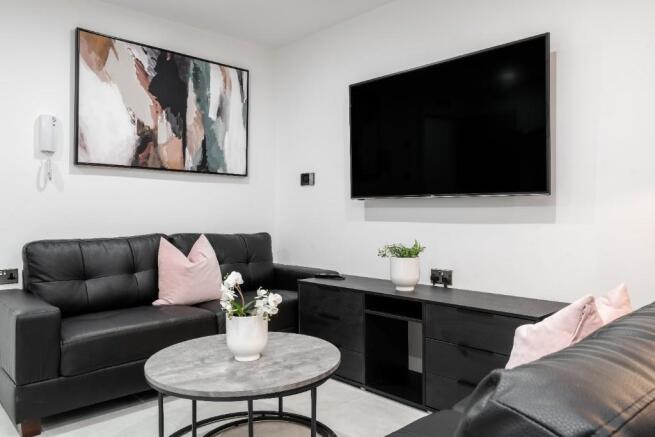 This contemporary living room features sleek bl...