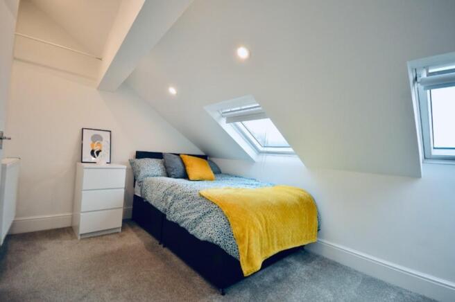 This inviting double bedroom features a cozy be...