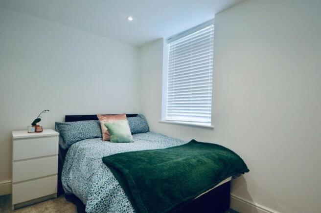 This cozy double bedroom features a comfortable...