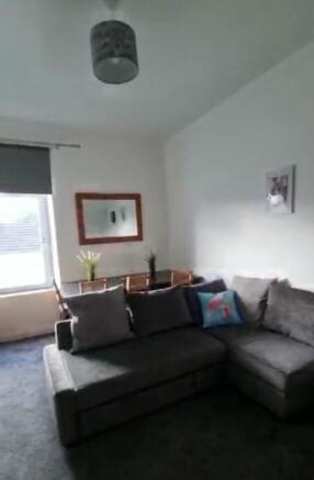 Bright living room featuring a comfortable grey...