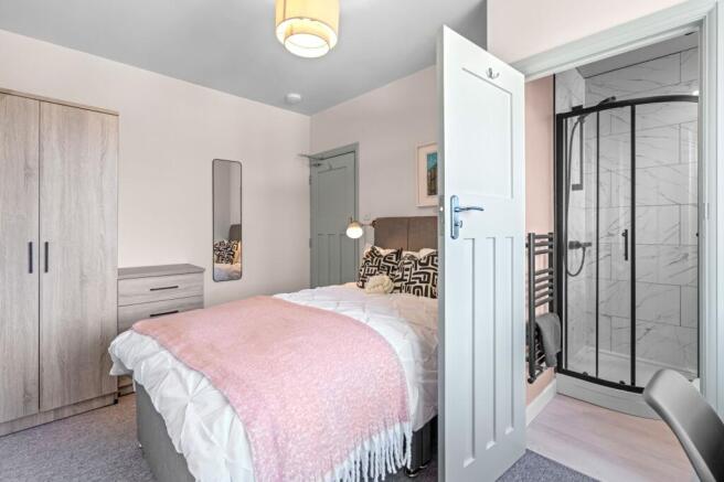 A bright and cozy master bedroom featuring a co...