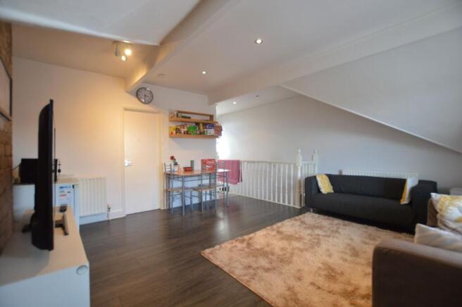 A cozy living area featuring dark wood flooring...
