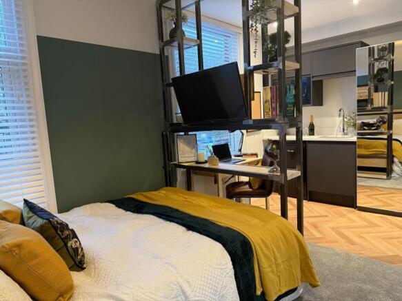 A stylish master bedroom featuring a comfortabl...