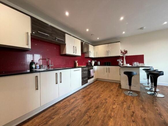 A modern and spacious kitchen with sleek cabine...