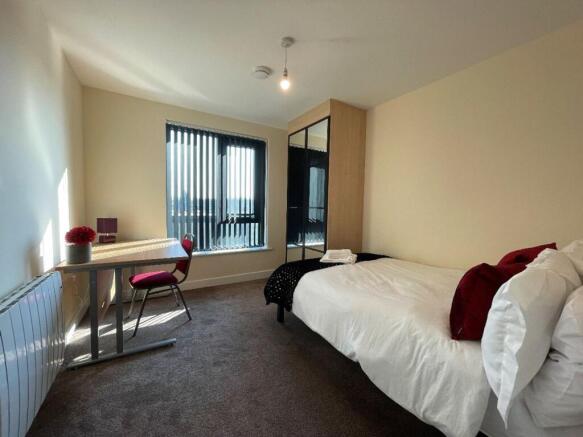 A bright and inviting double bedroom with ample...