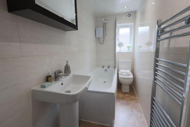 A modern and clean bathroom featuring a full ba...