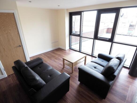 Bright and modern living room featuring large f...