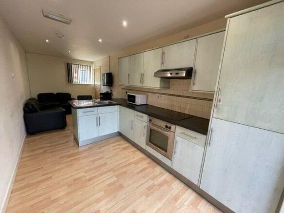 A modern kitchen space with light wood cabinetr...