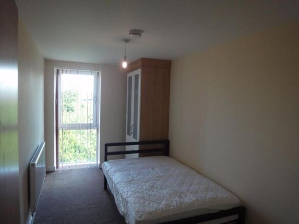 A spacious and bright double bedroom with large...