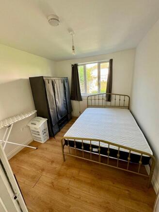 A bright double bedroom featuring a comfortable...
