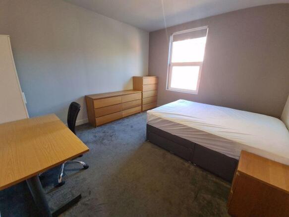 Bright and tidy master bedroom featuring a comf...