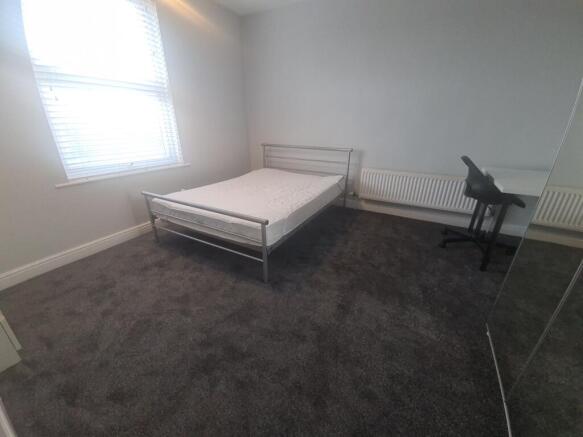 A spacious and clean bedroom featuring a double...