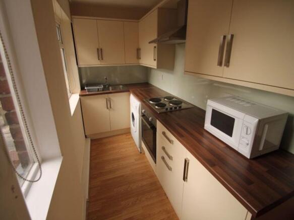 A bright, modern kitchen featuring a clean wood...