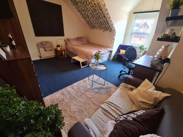 A spacious and cozy master bedroom featuring a ...