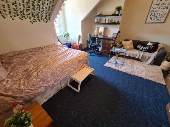 A spacious and cozy bedroom featuring a large d...