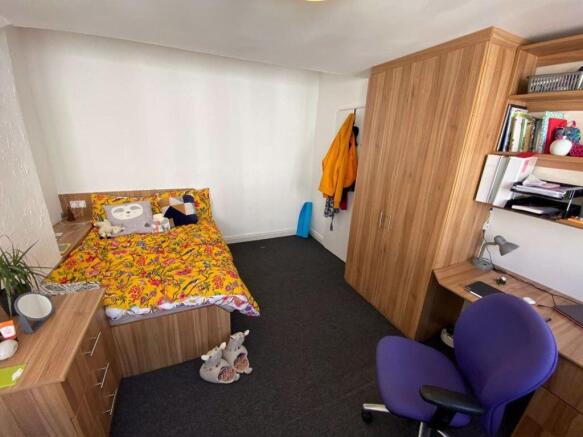 A cozy and well-organized bedroom featuring a d...