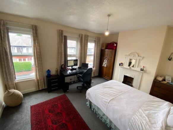 A spacious and bright bedroom featuring large w...