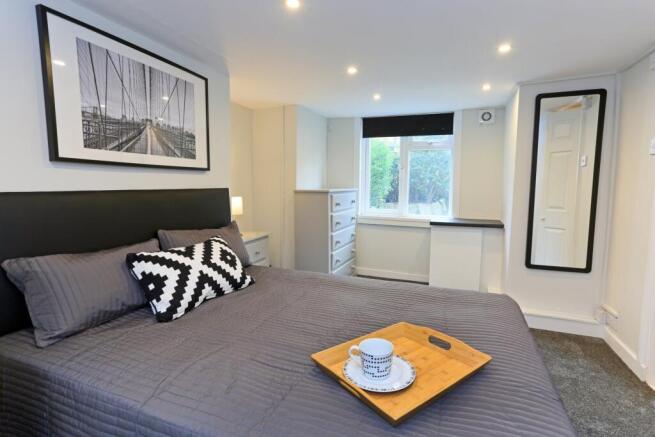 A modern master bedroom featuring a comfortable...