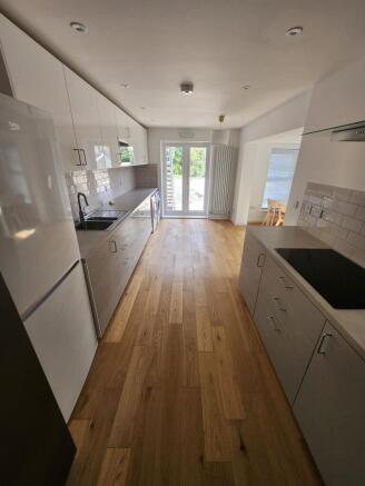 Modern and sleek kitchen featuring white cabine...