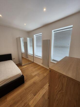 A bright and tidy double bedroom featuring thre...