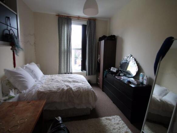 Bright and cozy master bedroom featuring a comf...