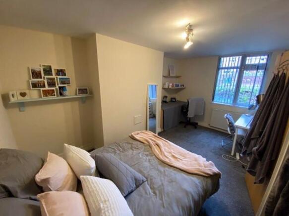 A cozy double bedroom featuring a neatly made b...