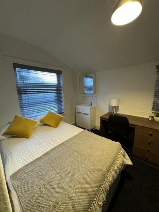 A cozy and well-kept double bedroom featuring a...