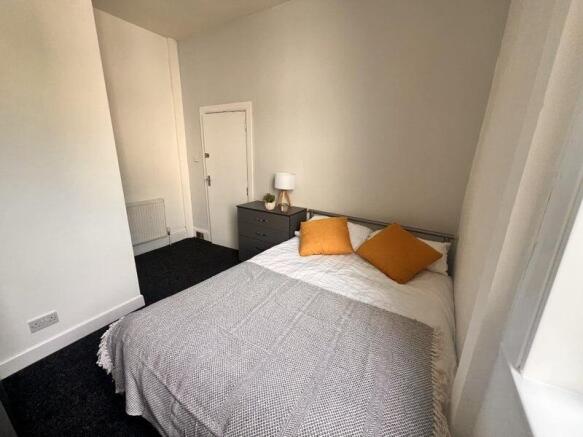 A cozy double bedroom featuring a neatly made b...