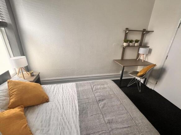A cozy double bedroom featuring a comfortable b...
