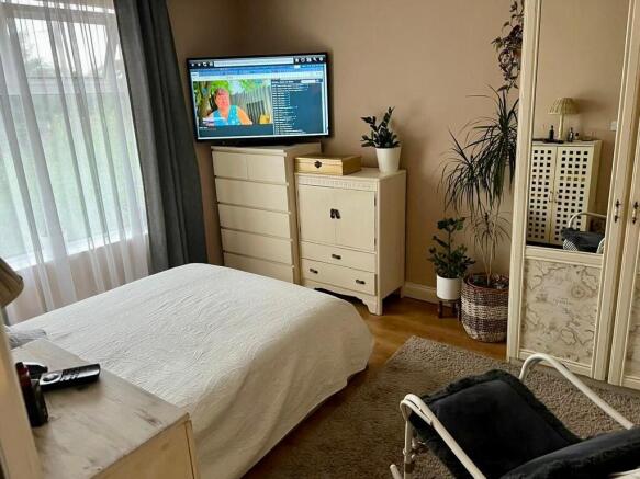 A cozy double bedroom featuring a large window ...