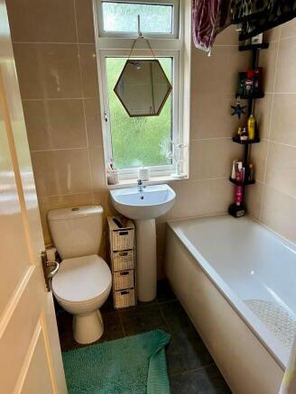 A bright and clean bathroom suite featuring a w...