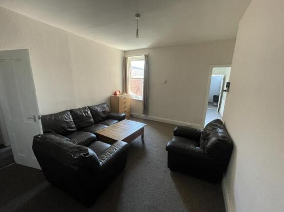 A cozy living room featuring a set of dark leat...