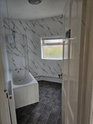 A modern bathroom suite featuring a white batht...