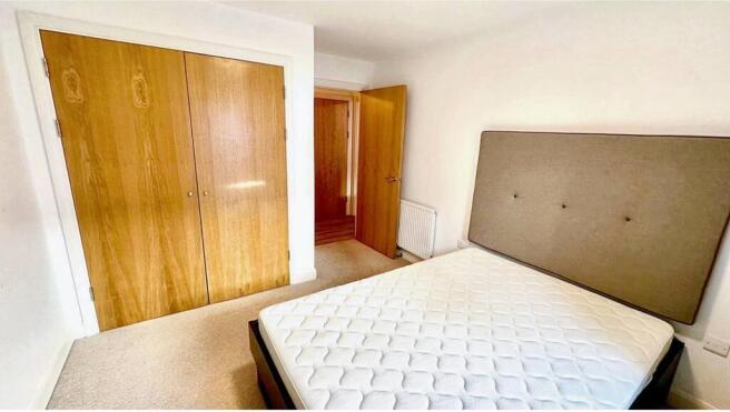 Bright double bedroom featuring a large window ...