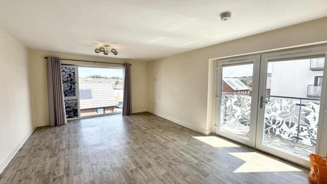 Bright and spacious living room featuring large...
