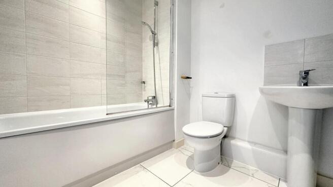 Bright and modern bathroom suite featuring a cl...