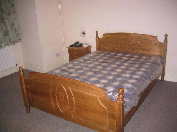 Cozy double bedroom featuring a classic wooden ...