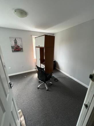 A modestly sized single bedroom featuring a sim...