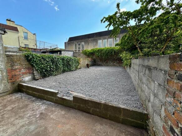 A tidy, enclosed garden area with a spacious gr...