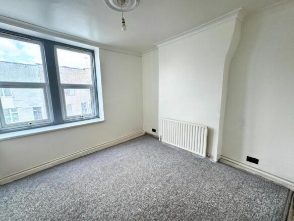 A bright and clean single bedroom featuring a l...
