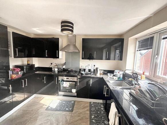 A modern kitchen with sleek black cabinetry, st...