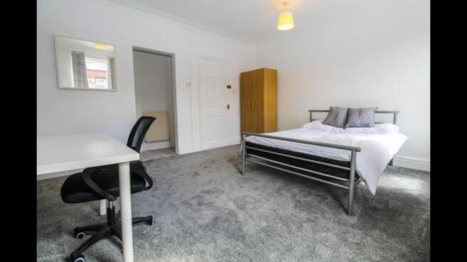 Bright and airy master bedroom featuring a comf...